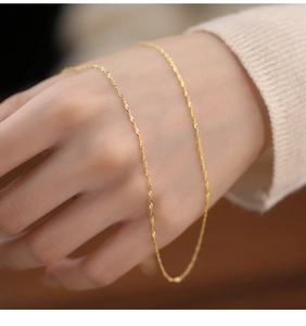 Close-up of a delicate 18K gold-plated S925 silver water wave chain on a wrist
