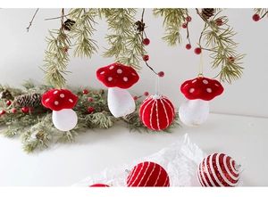 Close-up of red flocked mushroom and striped baubles hanging on a green Christmas tree