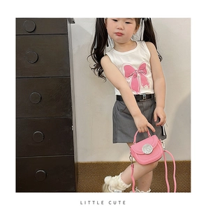 Close-up of girls white cotton vest with pink bow print and Little Cute text