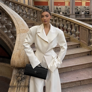 Chic white broad shoulder blazer suit for women with slim fit waist and black clutch bag