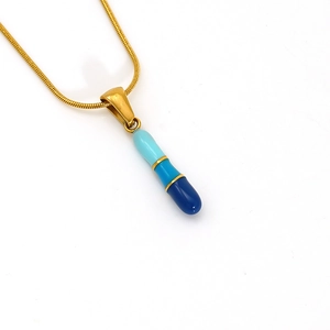 Detail shot of golden snake chain with three-tone blue enamel capsule pendant