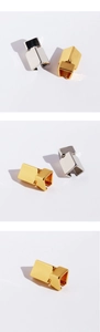 Close-up of geometric origami square ear cuffs in polished gold and silver finishes