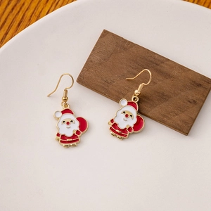 Macro view of Santa Claus drop earrings with festive red and white enamel on a gold hook
