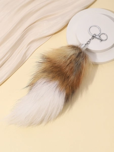 Detailed close-up of brown and white fox tail keychain with silver metal lobster clasp