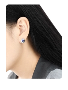 Detail of a minimalist oval lapis lazuli stud earring in S925 sterling silver on a female model