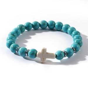 Cross beaded bracelet with turquoise stones and silver spacers on white background
