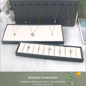 Macro detail of dark grey jewelry display set with necklace hooks and ring organizer tray
