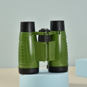 Detail view of military green children's toy binoculars on a light blue cylindrical stand