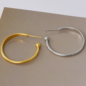 Detail of 925 sterling silver stamp on minimalist gold and silver hoop earrings