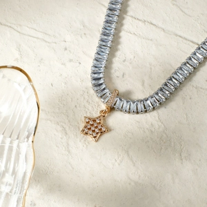 French style star pendant necklace with rectangular zircon stones on textured stone background