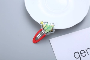 Detail of Christmas tree hair clip with green liquid glitter and a red festive snap base