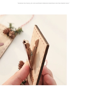 Macro side view of Christmas wooden photo clip showing natural wood grain and clip mechanism