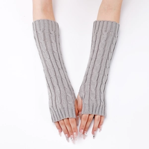 Detailed close-up of grey cable-knit arm warmers with thumb holes on a model