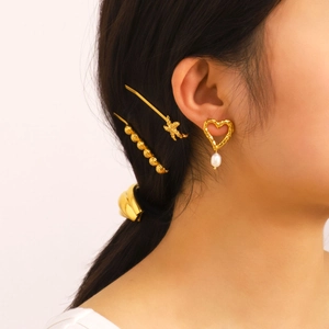 French vintage hollow heart pearl earrings and gold starfish hair clips on a model