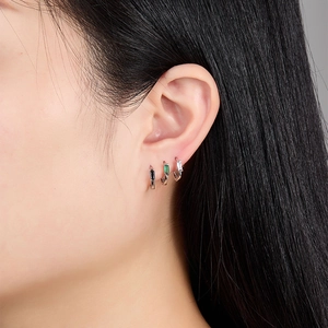 Close-up of S925 silver ear cuffs set with emerald and black cubic zirconia stones