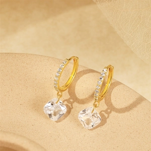 Close-up of gold s925 silver earrings with rectangular cubic zirconia pendants