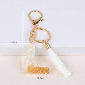 Letter L resin keychain with gold leaf, white shell flakes, and a stylish tassel charm