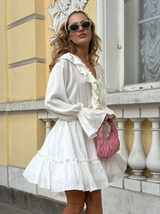 Close-up of white chiffon mini dress featuring layered ruffles and flared sleeves details
