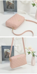 Pink quilted crossbody small square bag with metal detail and shoulder strap on white desk