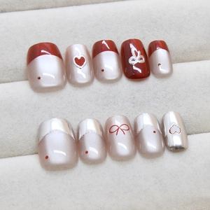 Handmade cat eye press-on nails with red bows and white hearts in 10-piece set