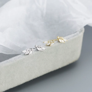 Macro view of 925 silver flower earrings with zircon stones in gold and silver finish