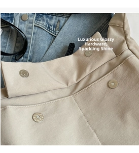 Detail of khaki canvas bag showing premium metal magnetic buckle and precise stitching