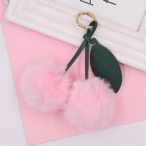 Pink plush cherry keychain with soft faux fur pom-poms and gold metal spring ring