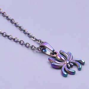 Macro detail of a spider pendant necklace with a vibrant iridescent rainbow metallic finish