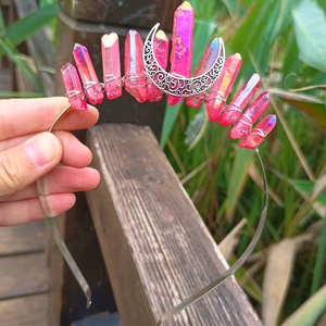 Detailed view of handmade silver crown with magenta crystals and a central hollow moon
