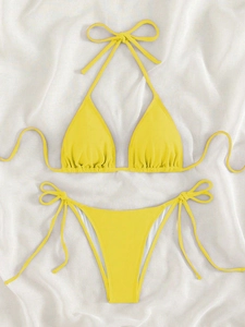 Detailed view of bright yellow ribbed bikini set with tie-up straps on white silk fabric
