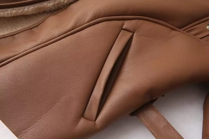 Détail de la veste en cuir marron avec poche latérale et doublure en peau lainée