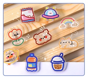 Detailed view of assorted cute acrylic snack clips with colorful cartoon patterns on wood