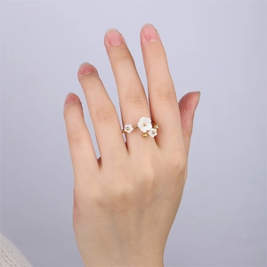 Bague élégante en or avec pétales de fleurs en nacre blanche et petits diamants