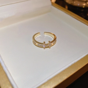 Detailed close-up of gold-plated open ring with sparkling cubic zirconia in jewelry box