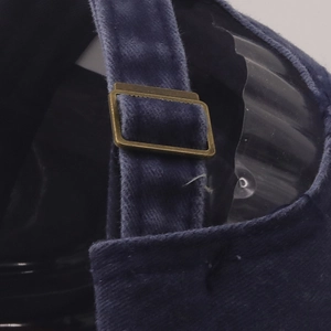 Détail d'une casquette en velours bleu marine avec boucle de réglage en métal laiton