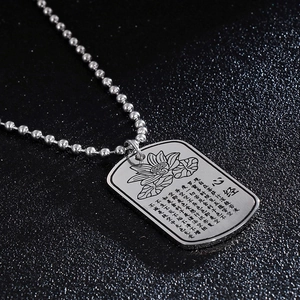 Detail of silver lotus dog tag necklace with engraved Buddhist Heart Sutra scriptures