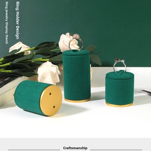 Three dark green velvet ring stands of varying heights with elegant gold metal bases