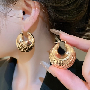 Macro shot of gold geometric textured earrings with classic quilted pattern detail