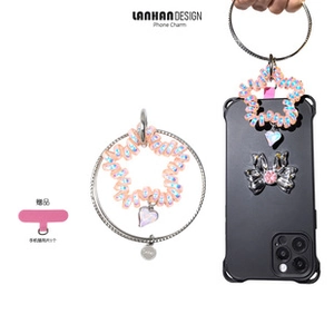 Pink spiral phone charm strap with metal ring and heart pendant detail on black case