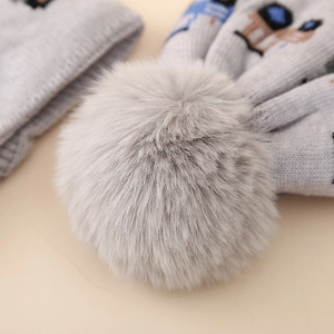Grey winter knit hat with large faux fur pom-pom and colorful cartoon pattern