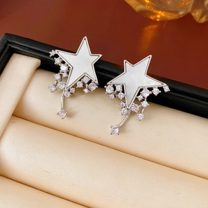 Detailed close-up of star earrings with white mother-of-pearl and cubic zirconia tassels