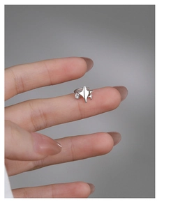 Detailed view of an S925 silver star ear cuff with a sparkling zircon on a model