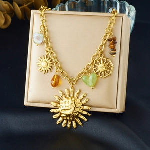 Detail of gold sun and heart charms with colorful beads on a premium jewelry box
