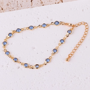 Detail of adjustable gold-plated chain bracelet with vibrant blue zircon gemstones
