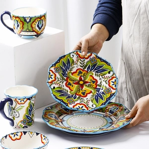 Hand-painted floral ceramic dinnerware set with wavy edges including plates, bowls and mugs