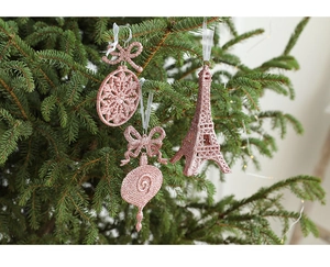 Pink glitter Eiffel tower and snowflake ornaments hanging on a green Christmas tree