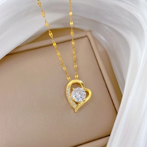 Macro shot of gold heart pendant with round central crystal and pavé diamond details