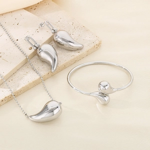 Detailed view of silver teardrop jewelry set including necklace, earrings and bangle