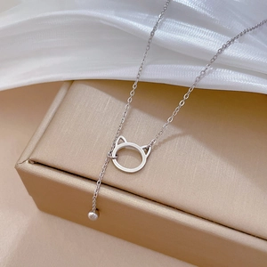 Macro detail of silver cat ear pendant and delicate bead on a fine titanium chain