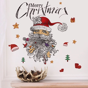 Stickers muraux de Noël avec Père Noël et étoiles sur un mur blanc au-dessus d'une étagère